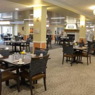 An empty dining area with neatly arranged tables and chairs under warm indoor lighting.