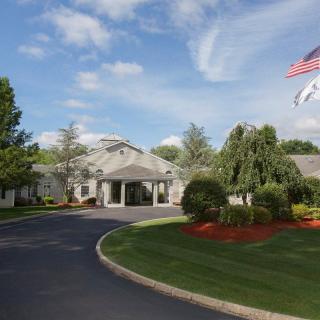 A building surrounded by well-maintained landscaping, with an American flag flying in the foreground.