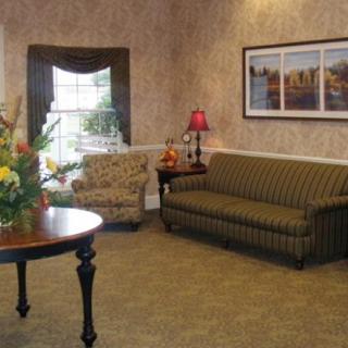 A cozy living room with a sofa, armchair, and decorative elements.