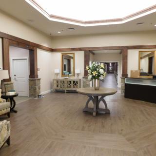 A spacious and elegantly decorated lobby area with a central table and reception desk.
