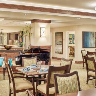 A warmly lit dining area with elegantly set tables and stylish artwork on the walls.