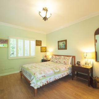 A cozy bedroom with a wooden bed, lamps on bedside tables, and elegant decor.