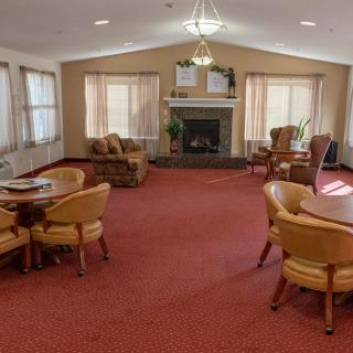 A cozy living room with comfortable seating, tables, and a fireplace.