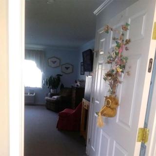 A cozy living room viewed through an open doorway, adorned with decorative elements.