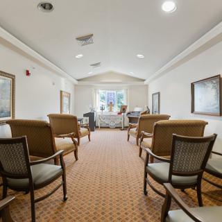 A well-lit waiting room with comfortable seating and a carpeted floor.