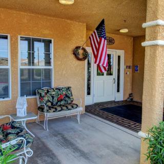 A welcoming front porch featuring an American flag, bench seating, and decorative elements.