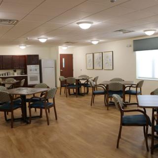 A clean and well-lit dining area with multiple tables and chairs.