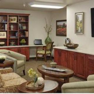 A cozy living room with wooden furniture, bookshelves, and a coffee table.