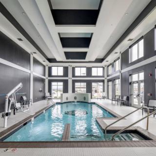 A modern indoor swimming pool with large windows and sleek architectural design.