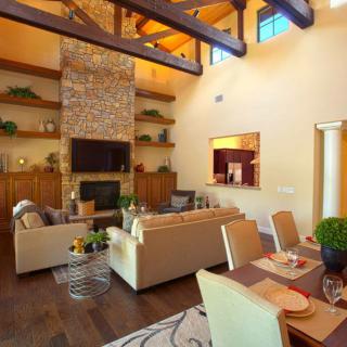 A modern and cozy living room with a fireplace and an adjoining dining area.