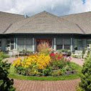 A charming house with a beautifully landscaped garden in front.