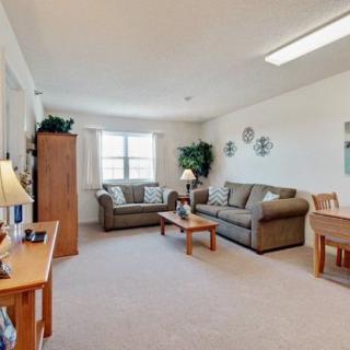 A cozy living room with comfortable sofas, a coffee table, and warm lighting.