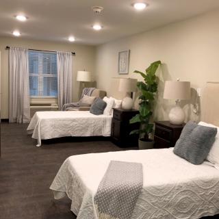 A cozy bedroom with multiple beds, elegant decor, and ambient lighting.