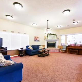 A spacious and brightly lit living room with cozy furniture and a fireplace.