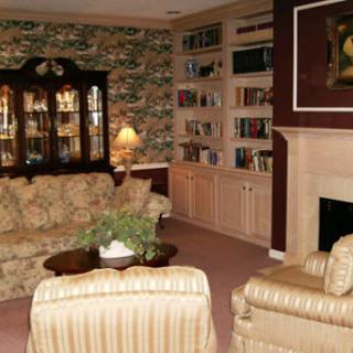 A warm and inviting living room featuring comfortable seating, a fireplace, and a collection of books.
