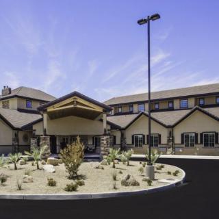 A modern building with a desert-style landscape at the entrance.