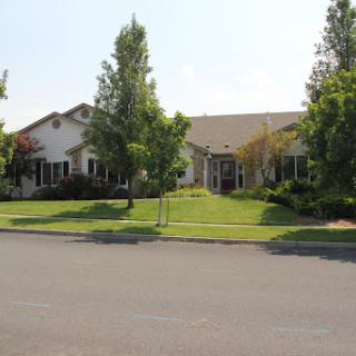 A view of a peaceful neighborhood featuring well-maintained houses and lush greenery.
