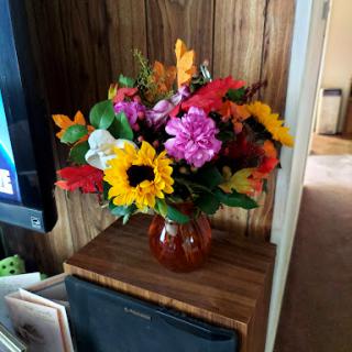 A vibrant bouquet of mixed flowers arranged in a decorative vase.
