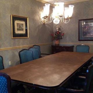 A formal dining room with a large table, elegant chairs, and a chandelier.