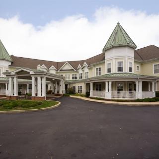 A large, elegant residential building with a covered entrance and driveway.