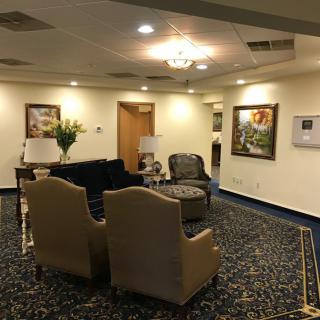 A spacious lobby area with comfortable seating, artwork on the walls, and elegant lighting.