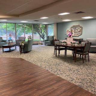 A cozy lounge area with comfortable seating, tables, and large windows providing natural light.