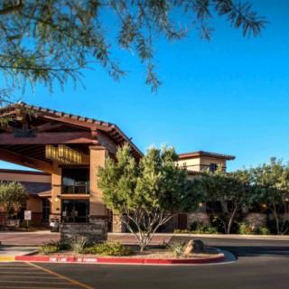 A hotel entrance surrounded by trees and landscaped greenery.