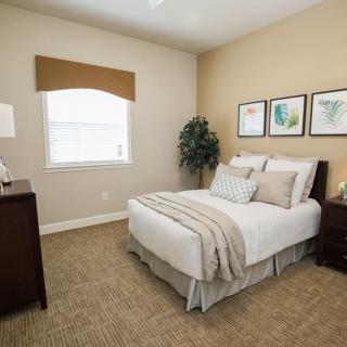 A cozy and minimalist bedroom with a neatly made bed, warm lighting, and simple decor.