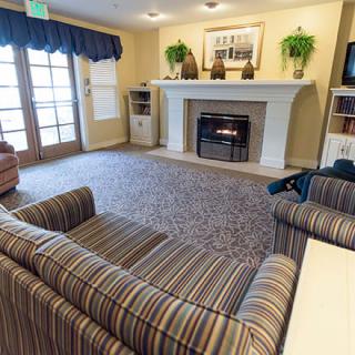 A cozy living room featuring a fireplace, striped sofas, and elegant decor.