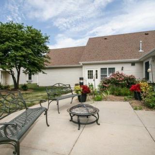 A cozy backyard patio with a fire pit and lush garden surroundings.