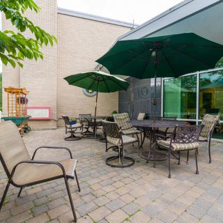 An inviting outdoor patio with tables, chairs, and large umbrellas for shade.