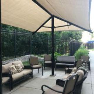 Outdoor patio seating area with umbrella and comfortable furniture.