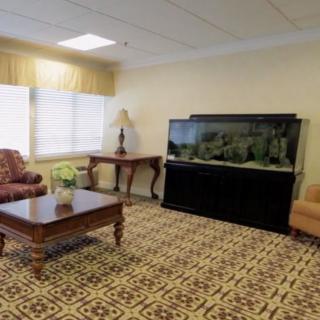 A cozy living room with a large fish tank and comfortable seating.