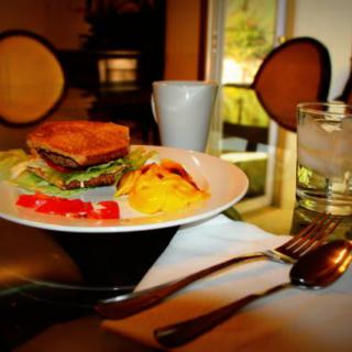 A breakfast plate featuring a sandwich and eggs is set on a dining table.