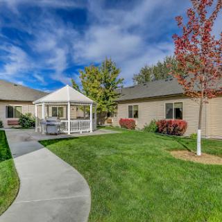 A serene residential area featuring a landscaped garden with a gazebo and well-maintained pathways.