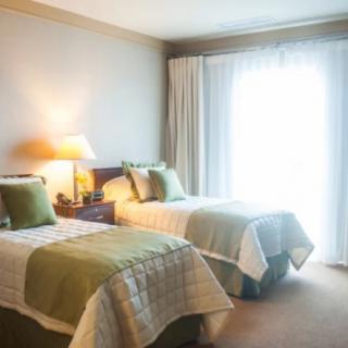 A cozy bedroom with twin beds and soft lighting.