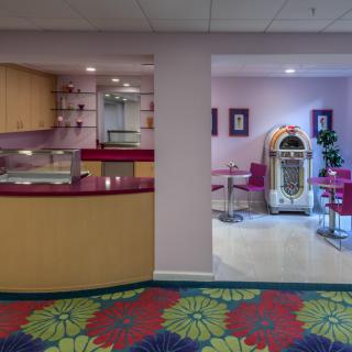 A retro-themed diner with a jukebox and colorful decor.