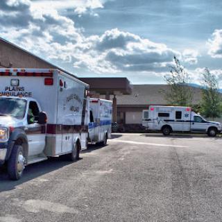 Ambulances parked outside a healthcare facility, ready to respond to emergencies.