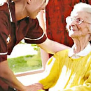 A nurse providing care and support to an elderly woman.