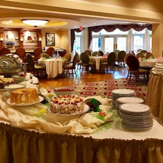 A well-arranged buffet setup in an elegant dining room, featuring a variety of desserts and neatly arranged tables.