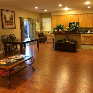 Spacious open-floor living area with a view of the kitchen.