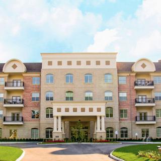 A multi-story residential building with a well-maintained exterior and landscaped front.