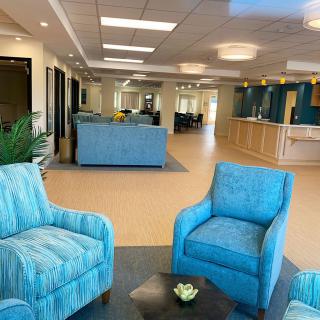 A modern lobby with comfortable blue seating and a reception area.