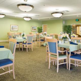 A well-lit dining room with neatly arranged tables and chairs, featuring elegant decor.