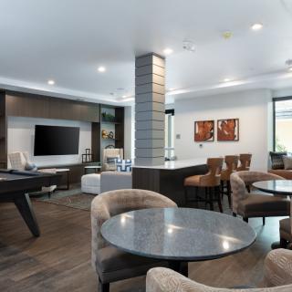 A modern living room with stylish furniture and a large television.