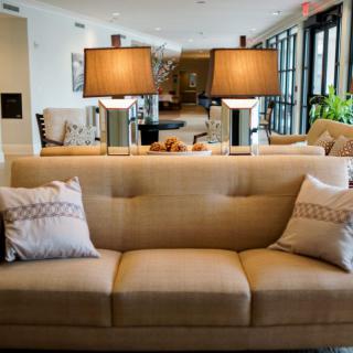 A well-decorated living room with a beige sofa and two stylish lamps.