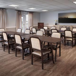 A conference room with multiple tables and chairs arranged for a meeting.