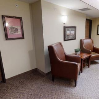 A cozy waiting area with leather chairs and framed artwork on the walls.