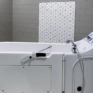 A modern bathtub in a stylish bathroom with geometric tile design.