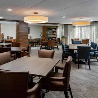 A spacious dining area with tables and chairs arranged neatly under warm lighting.
